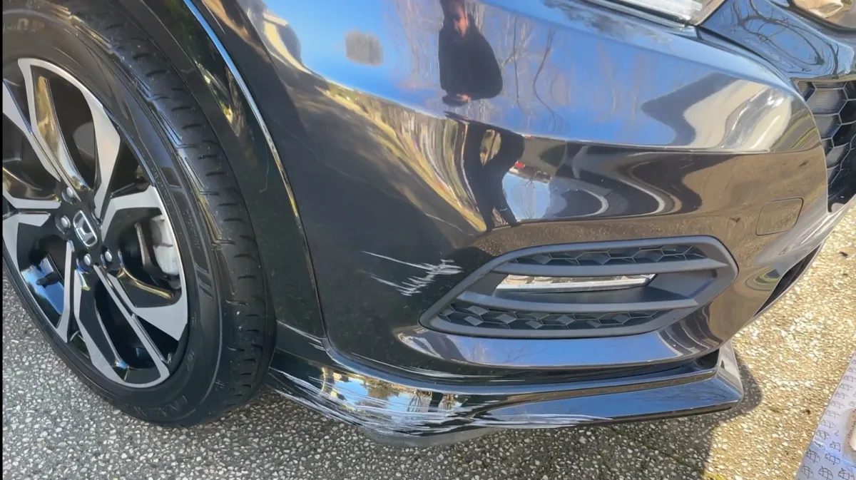 Front bumper lip scuff repaired in Brunswick — before